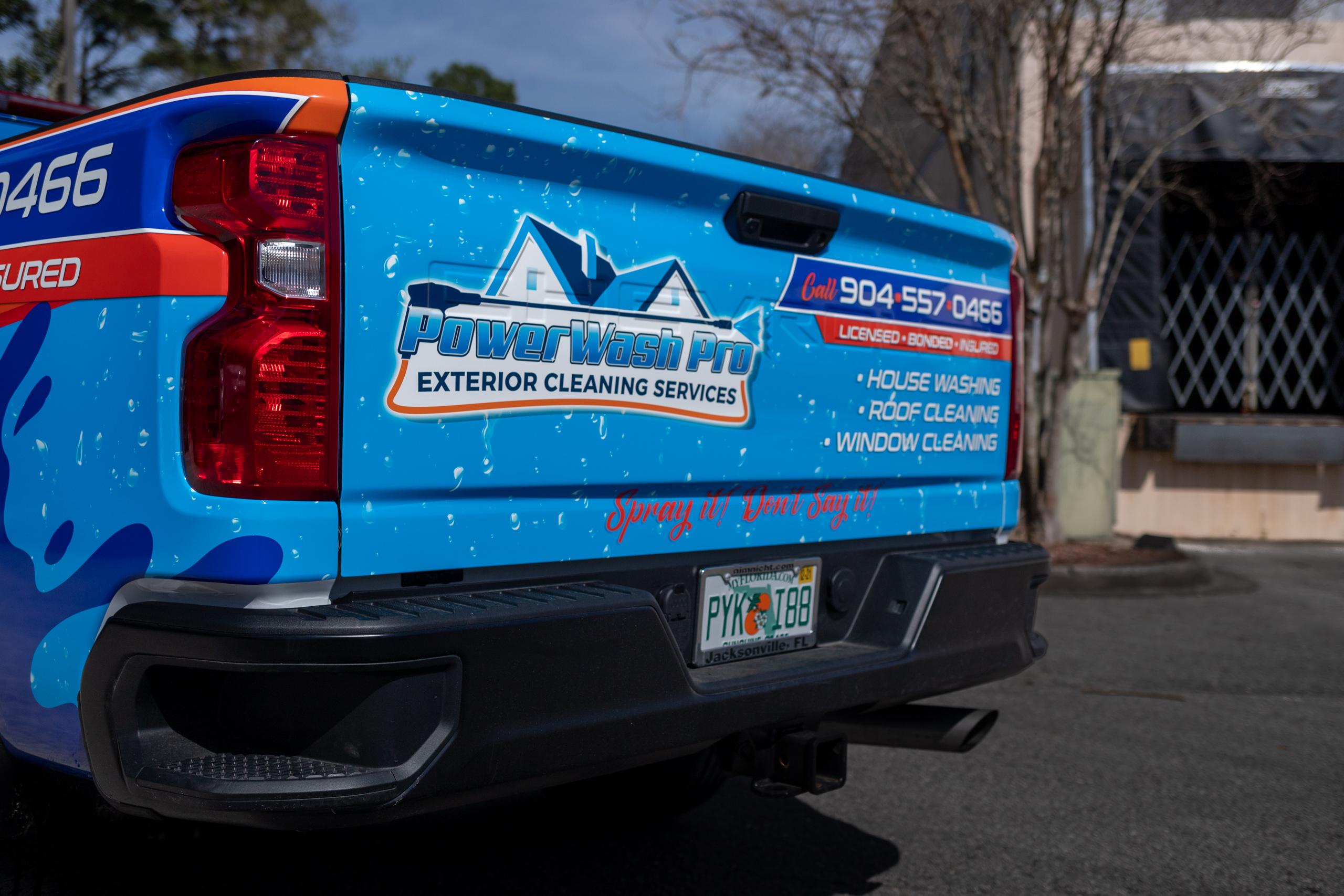 Tailgate of blue chevy truck with local business graphic.