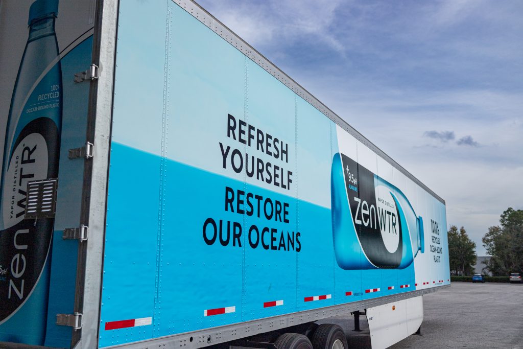 A blue and white box truck wrapped in a business graphic.
