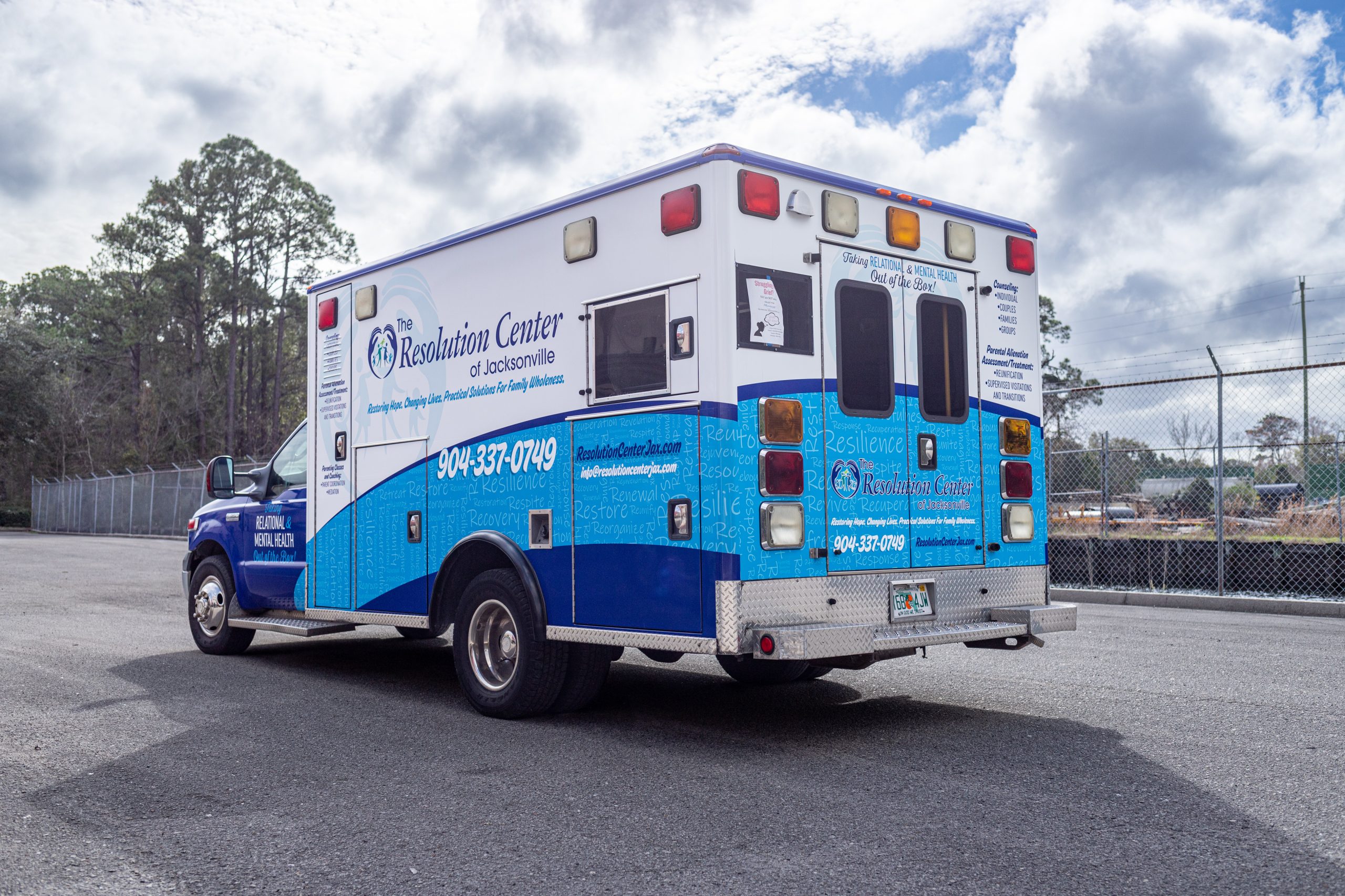 Ambulance style van with local business graphics.
